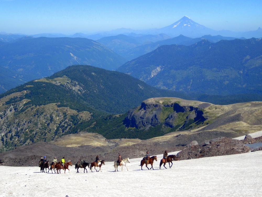Riders on horseback on the slope of Sollipulli volcano